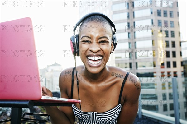 Portrait of Black DJ laughing on urban rooftop