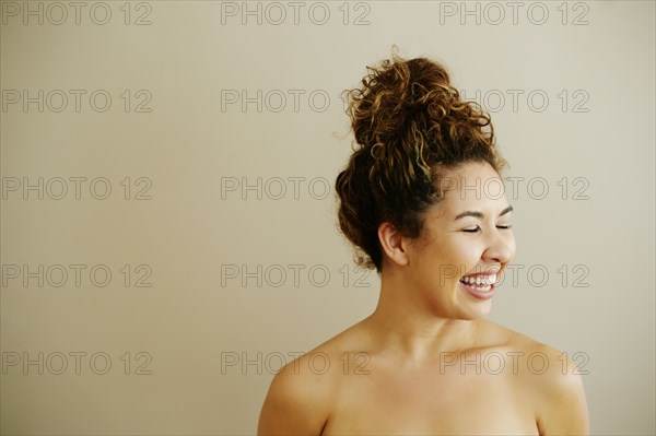 Portrait of laughing naked Mixed Race woman