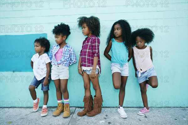 Girls leaning in blue wall