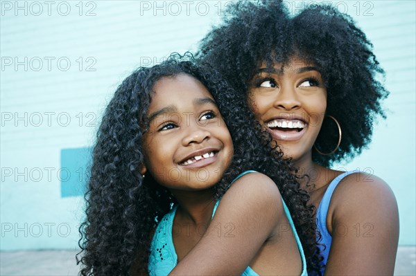 Black mother and daughter looking away