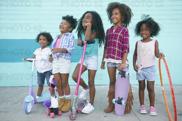 Smiling girls standing on sidewalk with transportation