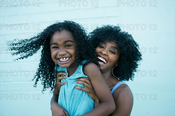 Portrait of Black mother and daughter laughing