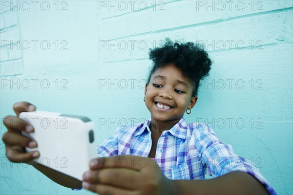 Black girl posing for cell phone selfie