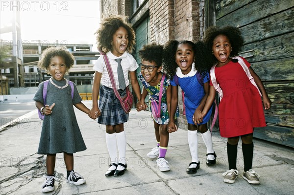 Portrait of girls laughing on sidewalk