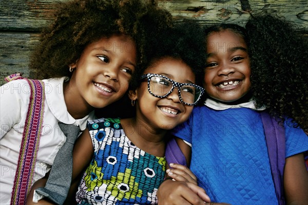 Portrait of smiling girls near wooden wall