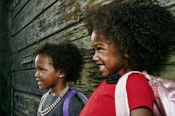 Laughing girls near wooden wall