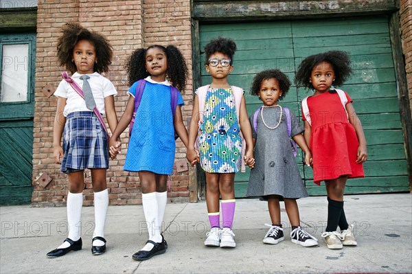 Serious girls posing on city sidewalk