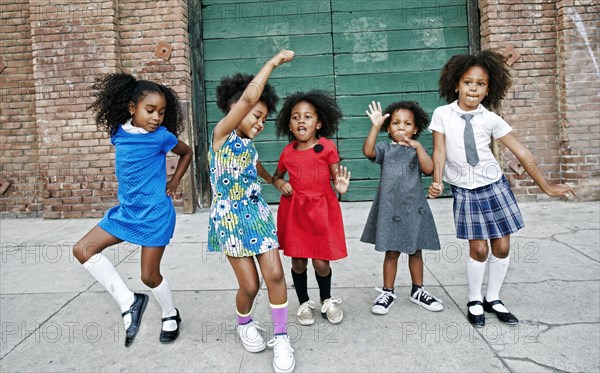 Girls dancing on city sidewalk