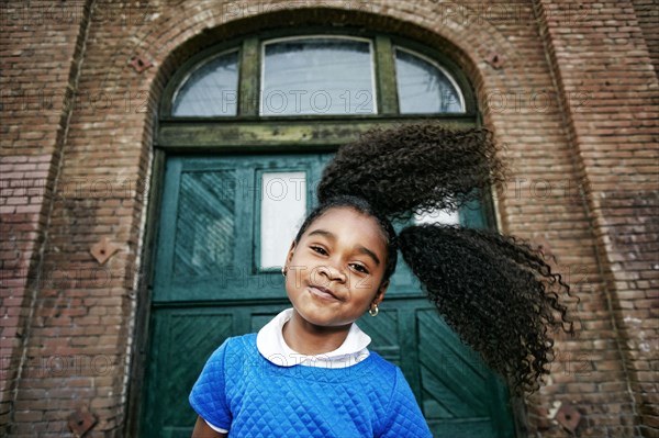 Smiling Black girl tossing hair