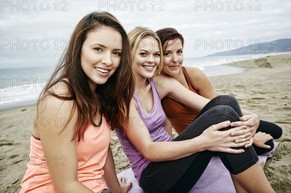 Portrait of smiling Caucasian women sitting on beach