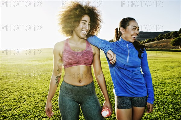 Women laughing in sunny field