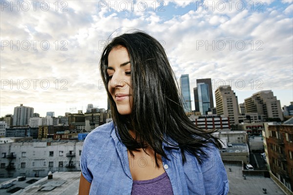 Portrait of smiling Hispanic woman on urban rooftop