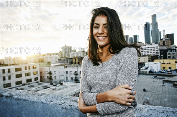 Portrait of smiling Hispanic woman on urban rooftop