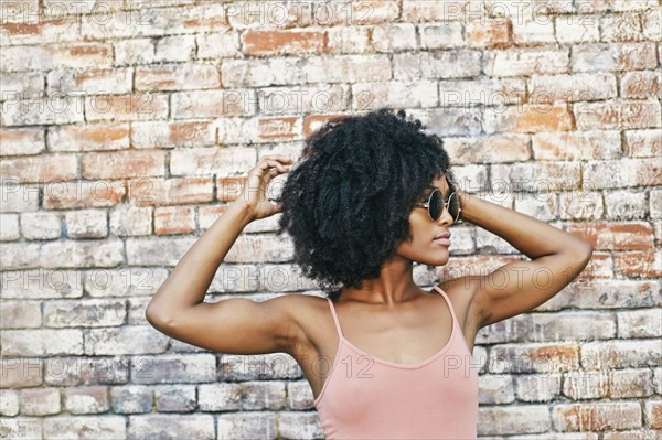 Serious Black woman near brick wall