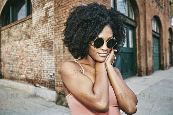 Black woman near corner of brick building