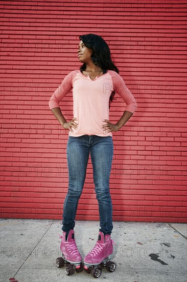 Black woman wearing roller skates on sidewalk