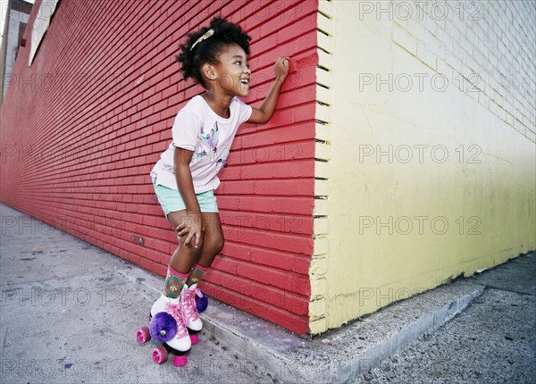 Black girl wearing roller skates peeking around corner
