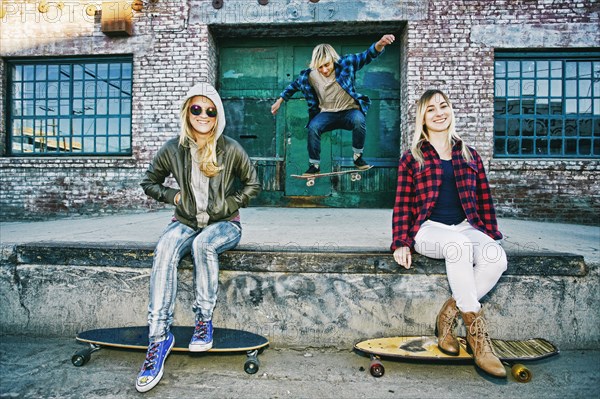 Friends with skateboards smiling on loading dock