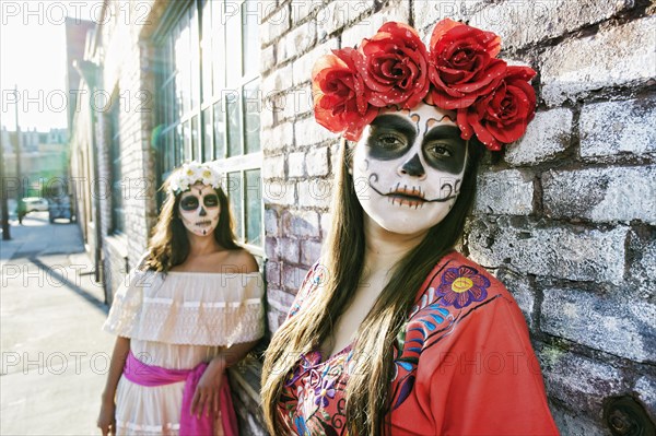 Women on sidewalk wearing skull face paint