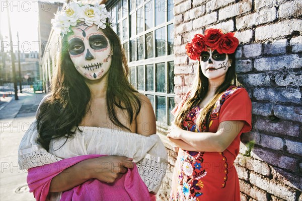 Women on sidewalk wearing skull face paint