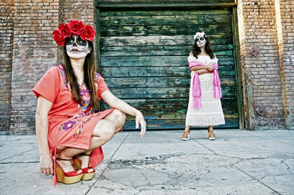 Women on sidewalk wearing skull face paint