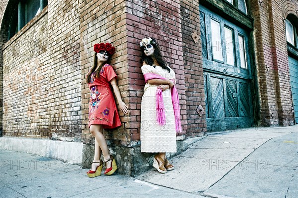 Women on sidewalk corner wearing skull face paint