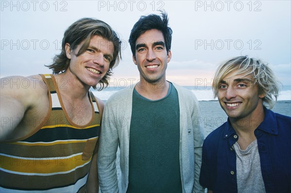 Portrait of smiling Caucasian men at beach