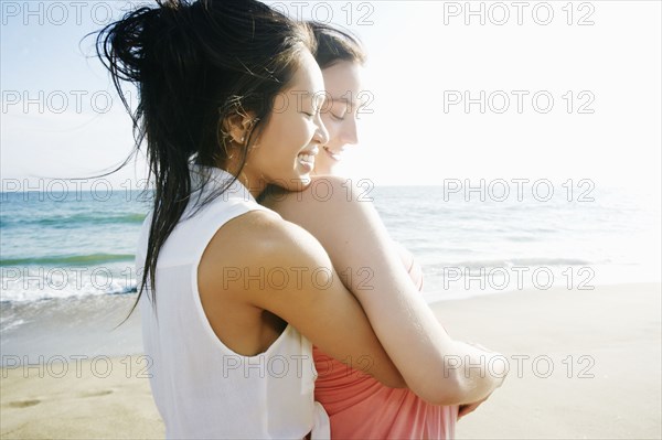 Women hugging at beach