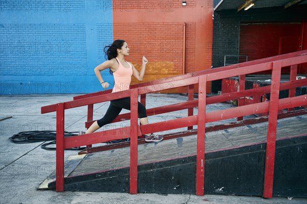 Mixed race woman running up loading dock