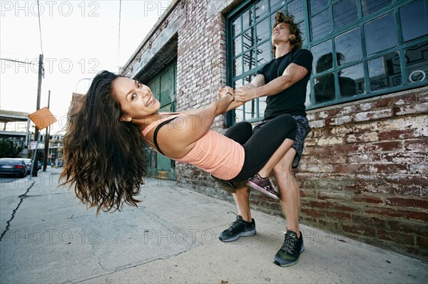 Woman balancing on thighs of man