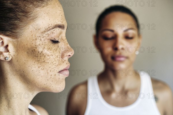 Close up of mixed race women with eyes closed
