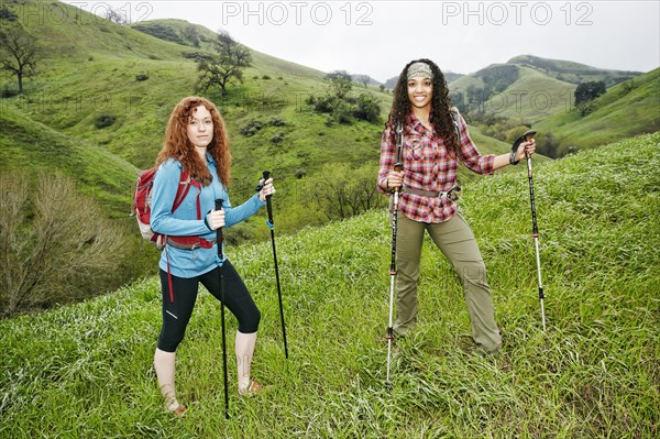 Portrait of smiling women hiking with walking sticks