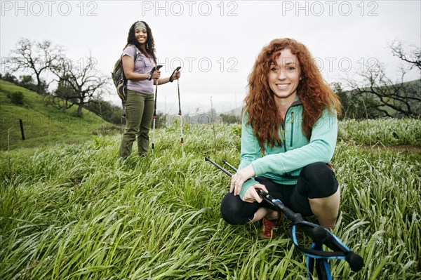 Portrait of smiling women hiking with walking sticks
