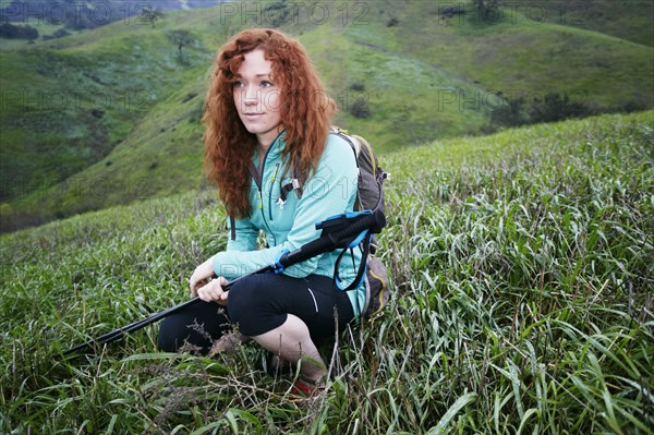 Portrait of Caucasian woman crouching holding walking sticks