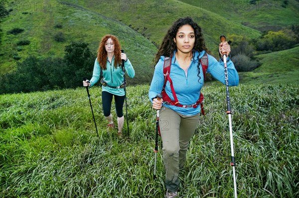 Serious women hiking with walking sticks