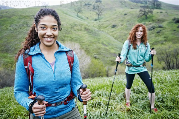 Portrait of smiling women hiking with walking sticks