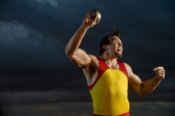 Caucasian athlete throwing shot put