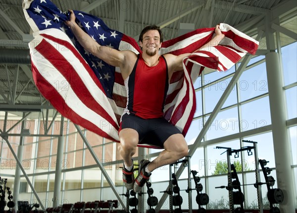 Caucasian athlete jumping with American flag