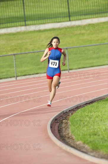 Japanese runner running on racetrack