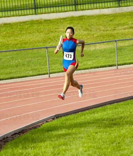 Japanese runner running on racetrack