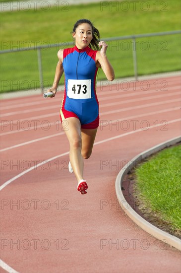 Japanese runner running on racetrack