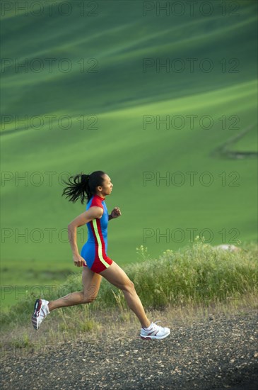 Mixed race runner running in countryside