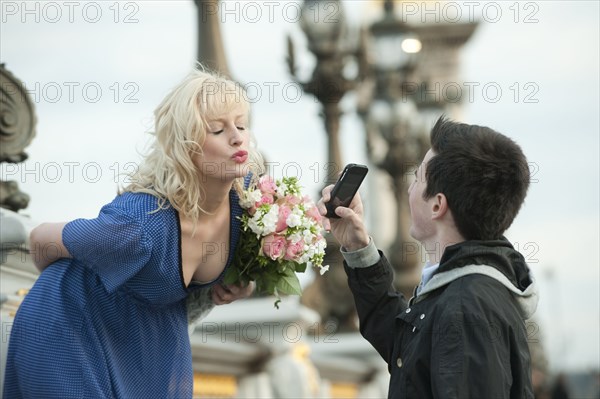 Caucasian man photographing girlfriend