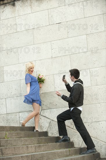 Caucasian man photographing girlfriend