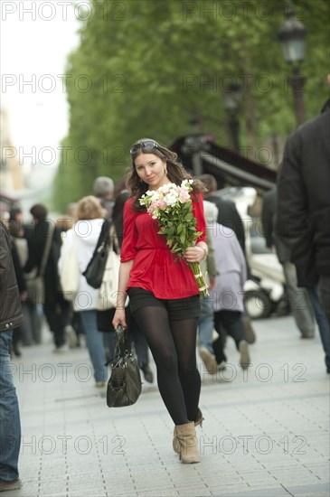 Smiling Caucasian woman walking with bouquet