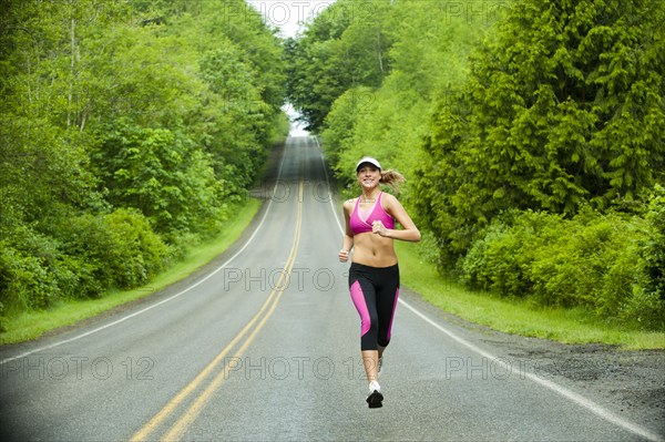 Caucasian woman running on remote road