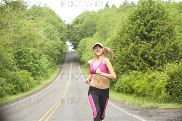 Caucasian woman running on remote road