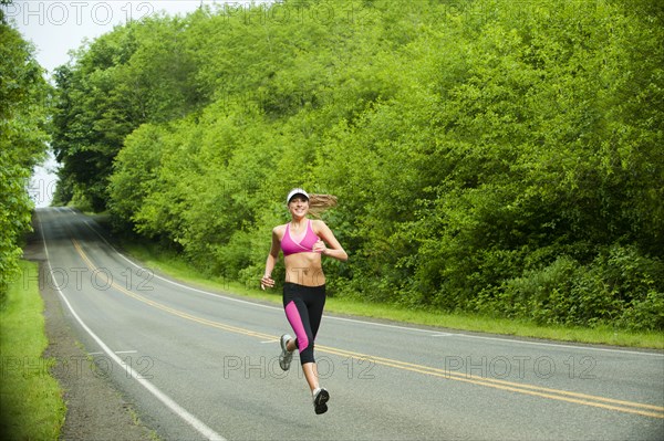 Caucasian woman running on remote road