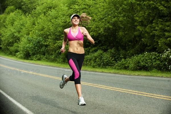 Caucasian woman running on remote road