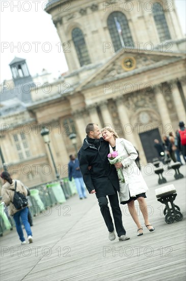 Caucasian couple walking in city plaza